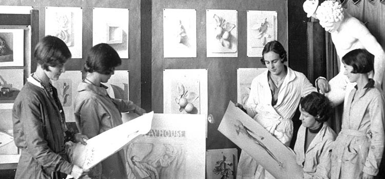 Old photograph of women looking at drawings