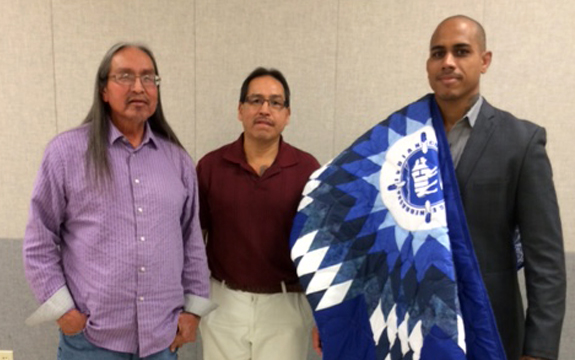 Stephane Shephers stands with two Native Americans