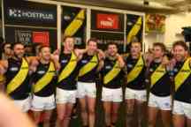 Group of Richmond footballers arm in arm singing the theme song after a win