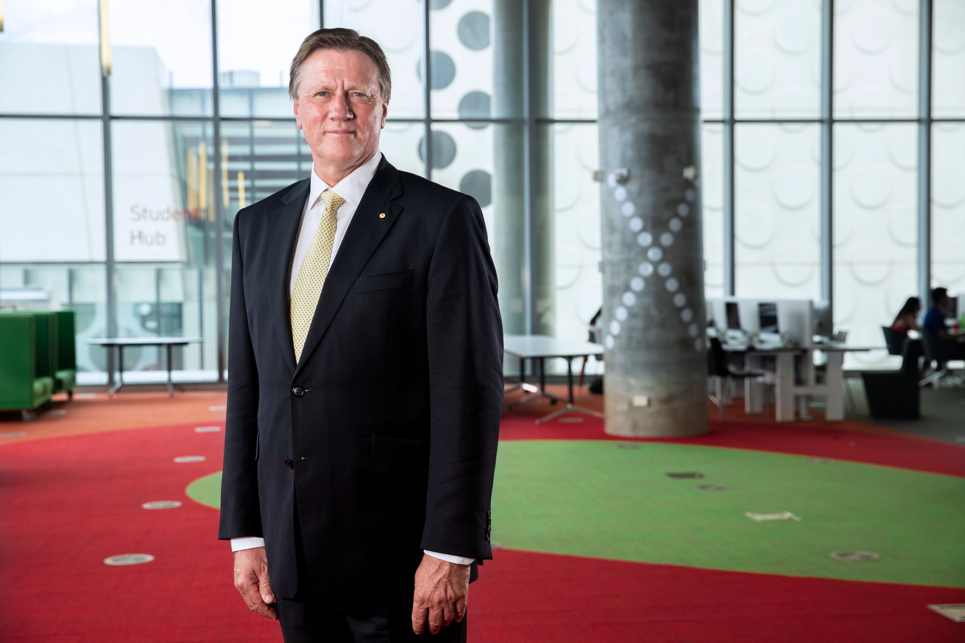 Chancellor of Swinburne stands wearing a suit looking to camera