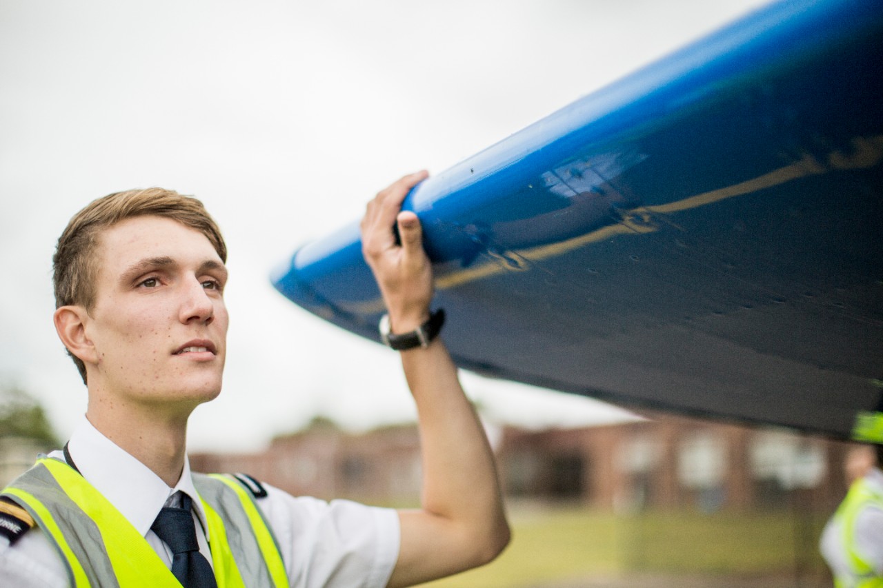 A professional piloting student standing next to an airplane at the Moorabbin Airport