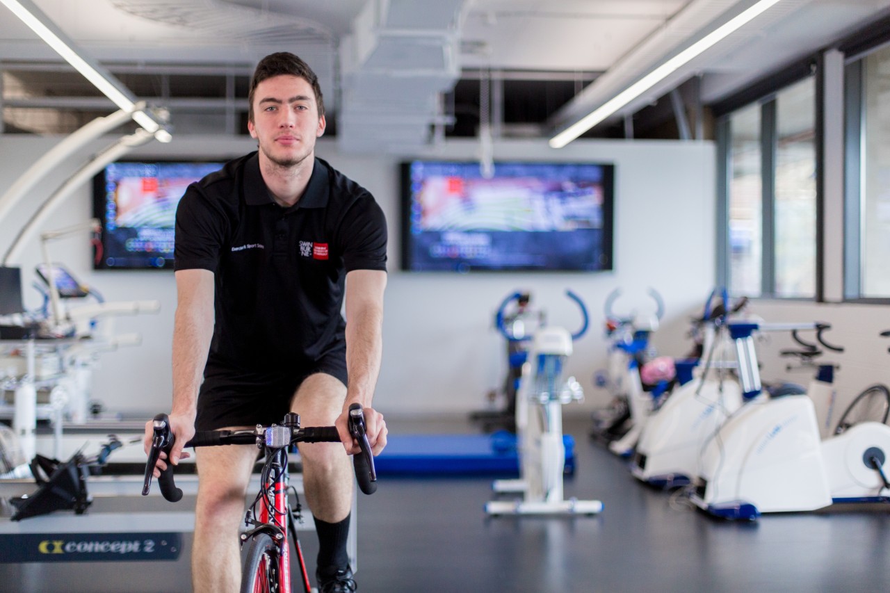 Male student wearing Swinburne apparel using a specialised exercise bike