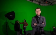 Associate Professor Dan Golding standing in front of a green screen in a film studio - cropped