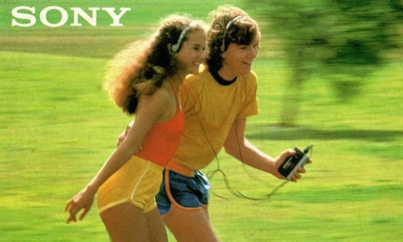 A man and woman listening to a Walkman while rollerskating.