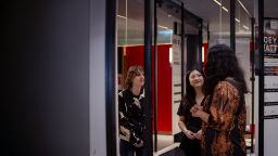 Three people standing talking