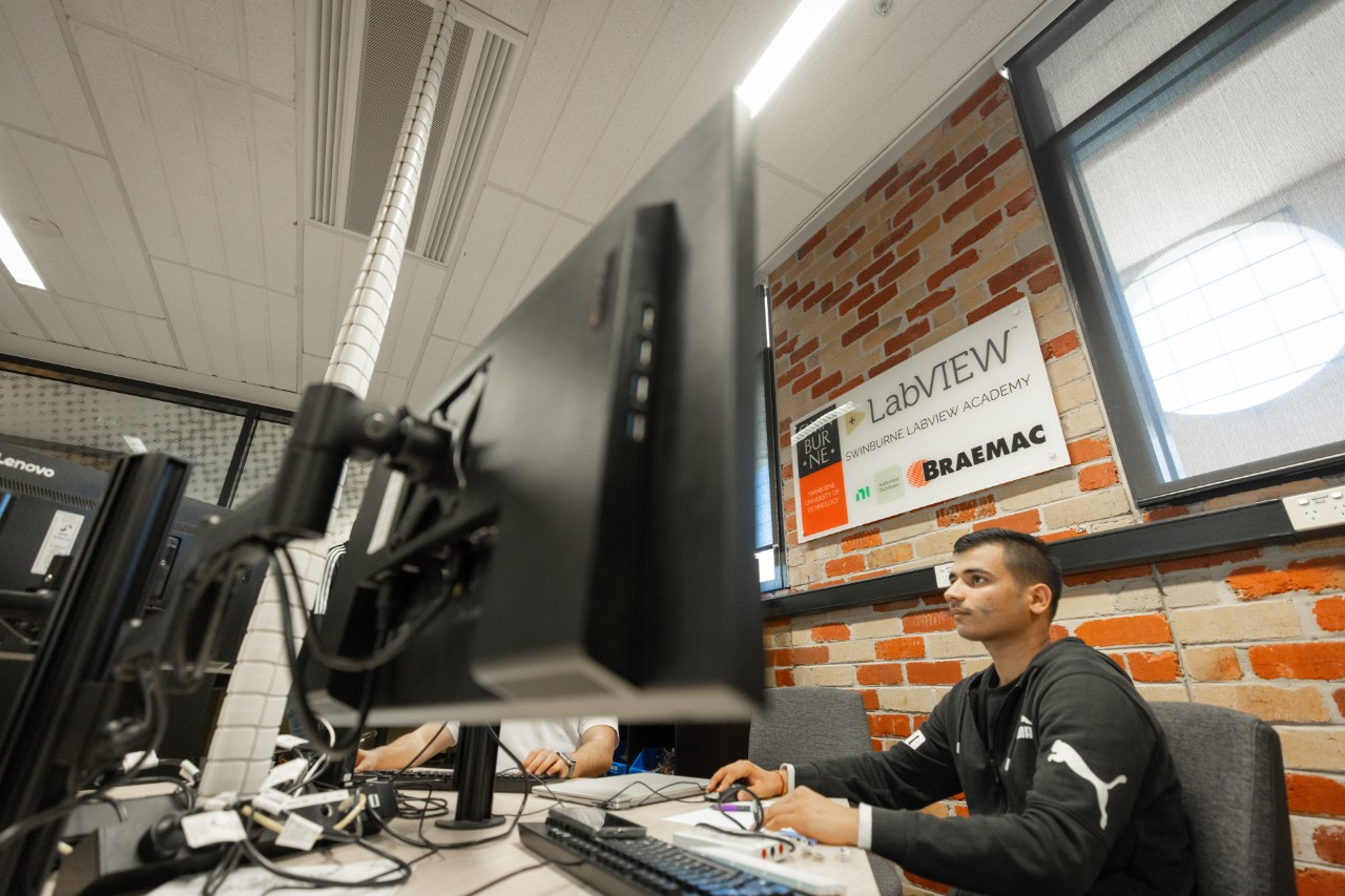 A student using a computer in the National Instruments LabVIEW Academy