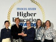 Five women stand in front of a media wall reading 'Financial Review Higher Educations Awards'. Swinburne Vice-Chancellor and President Professor Pascale Quester and Employability Director Professor Ruth Bridgstock hold a trophy.