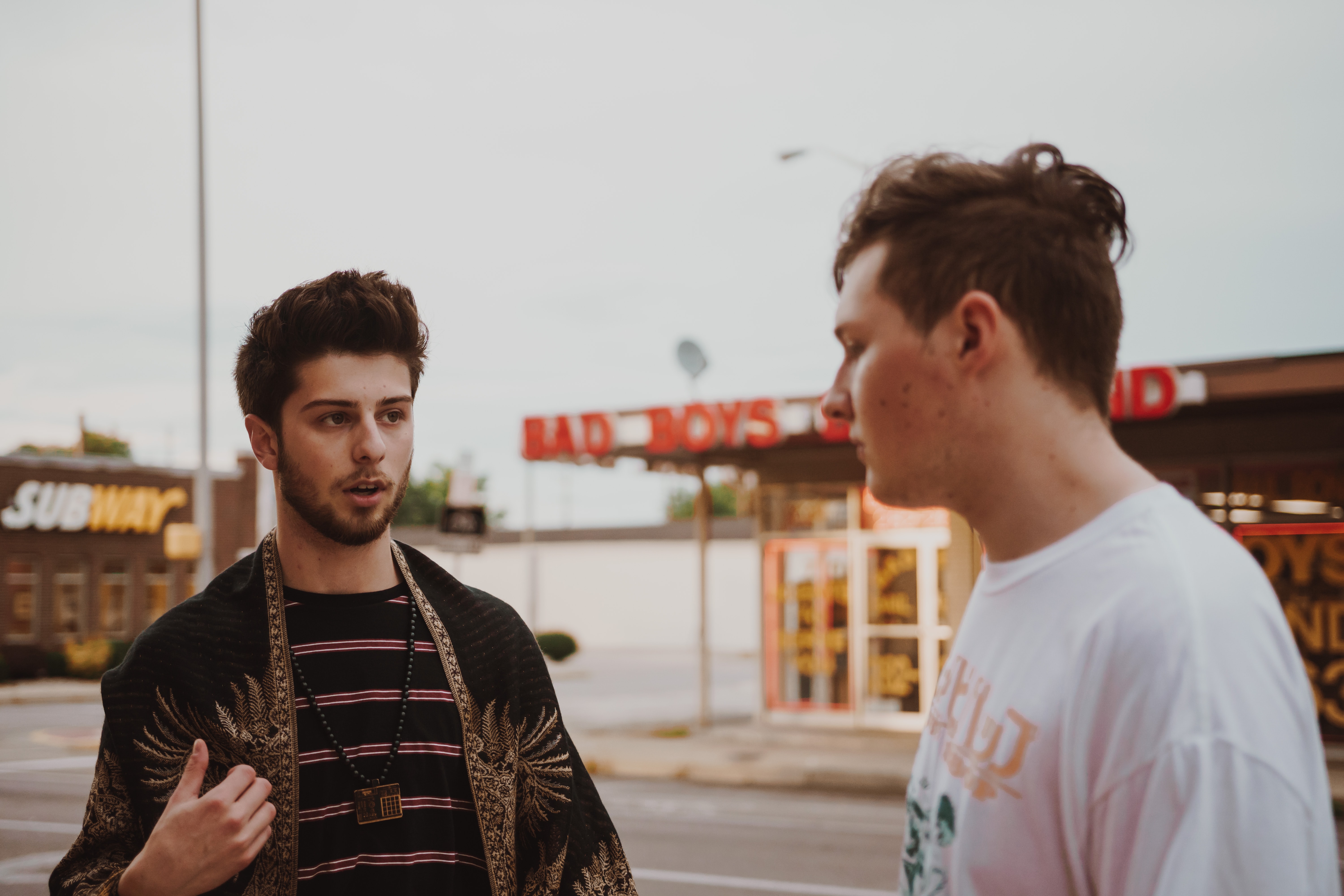 Stock image of two young men having a conversation in a suburban street