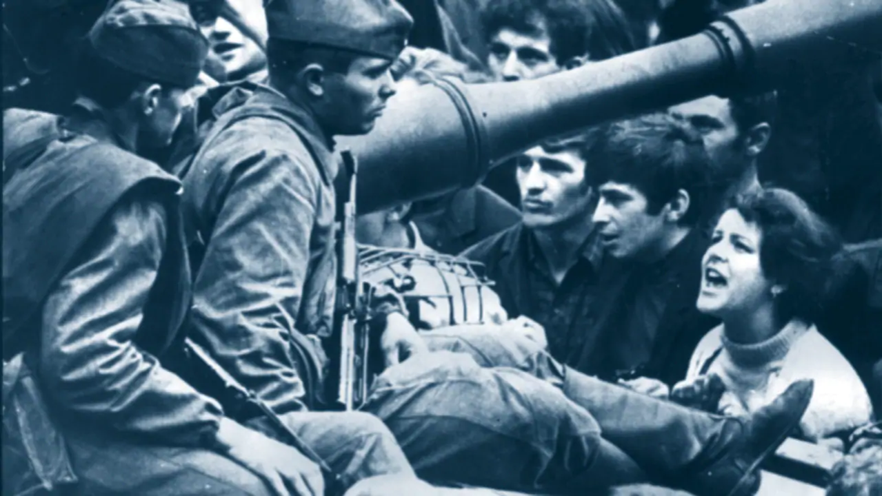 Soviet soldiers sitting on a tank  opposing Czechoslovakian citizens in 1968
