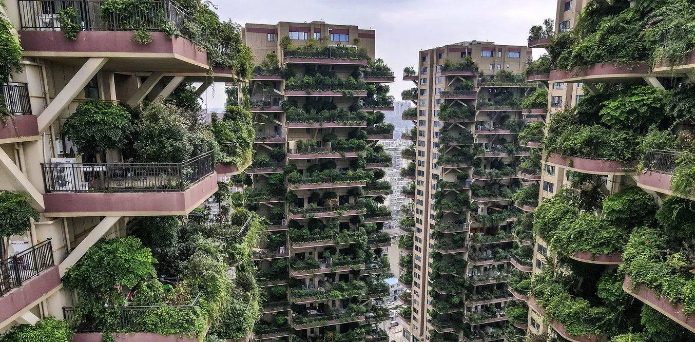 A complex of residential building clad with large amounts of green plants