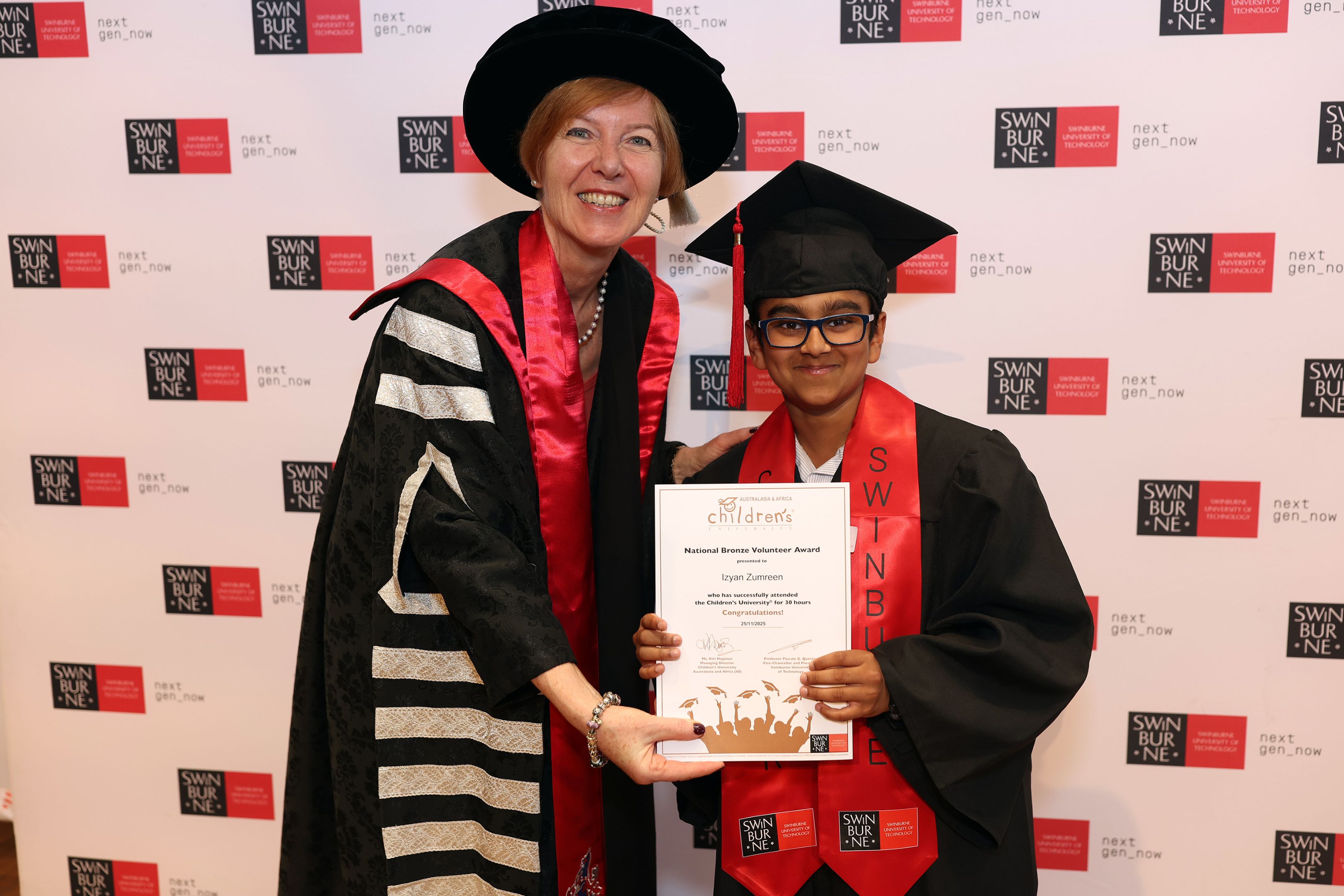 Pascale Quester poses for a graduation photo next to young Izyan