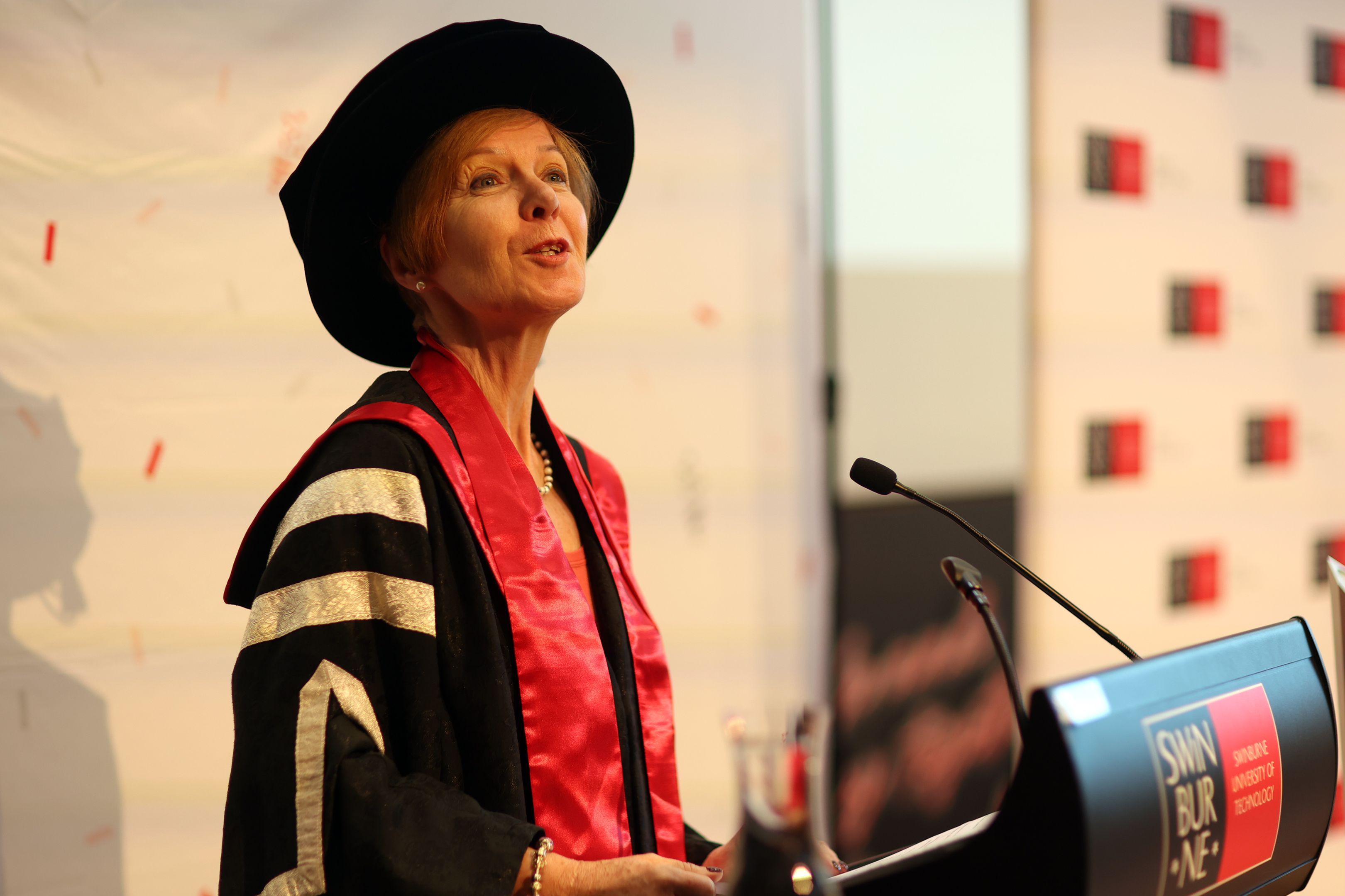 Pascale Quester stands at a lectern delivering a speech