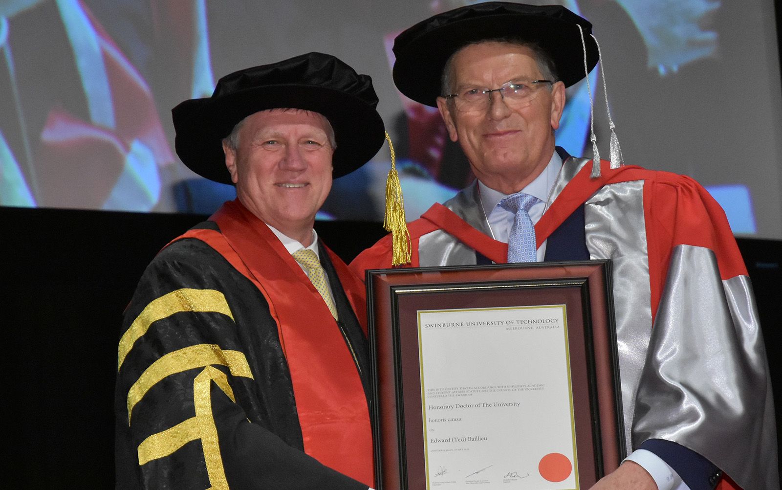 Chancellor Professor John Pollaers and Ted Baillieu in academic regalia at August 2022 graduations