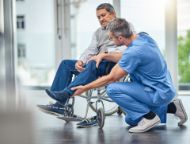 A nurse helping a senior man in a wheelchair