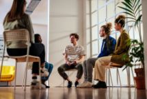 Young people in group counselling sitting on chairs in circle