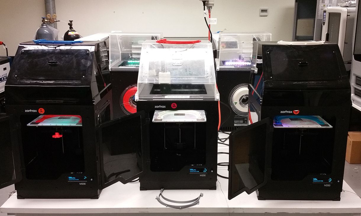 Three 3D printers printing SwinShield face shields