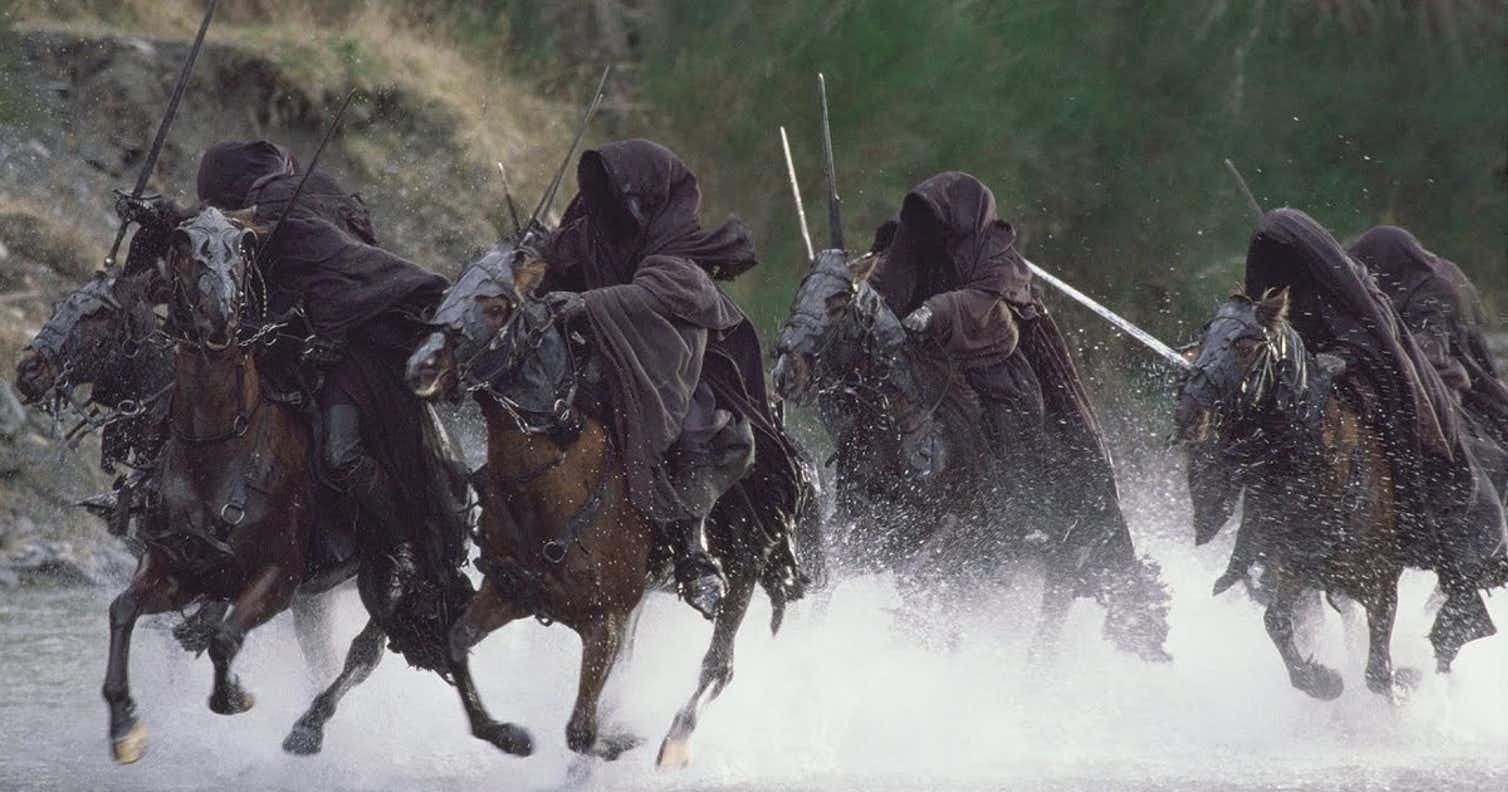 The Nazgul from Lord of the Rings are riding horses, armed with swords and dressed in dark cloaks