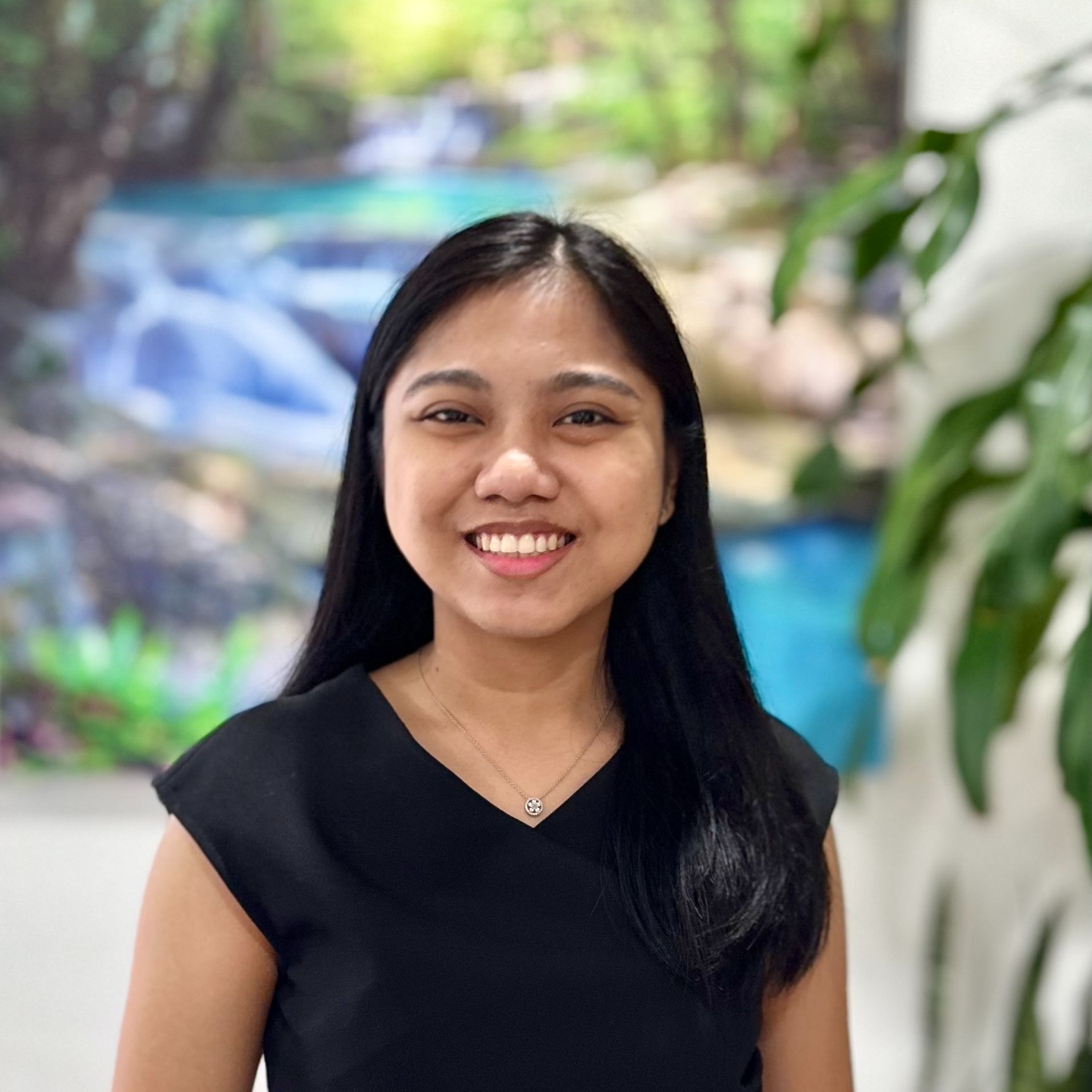 Young lady standing in front of a blurred neutral background. 