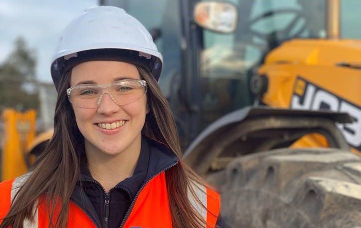 Photograph of Decmil professional placement student Kelsey Ingham wearing a hard hat and safety vest on a construction site.