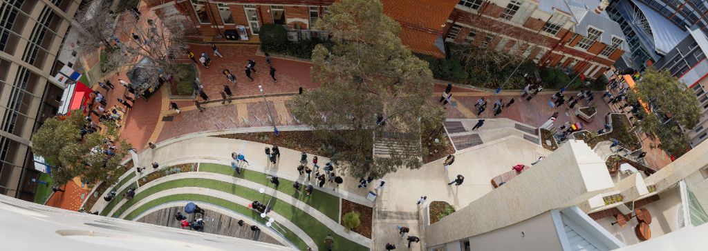 Young woman standing on a train as doors open to reveal a film set behind her.