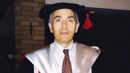 A man wearing a graduation cap and gown.