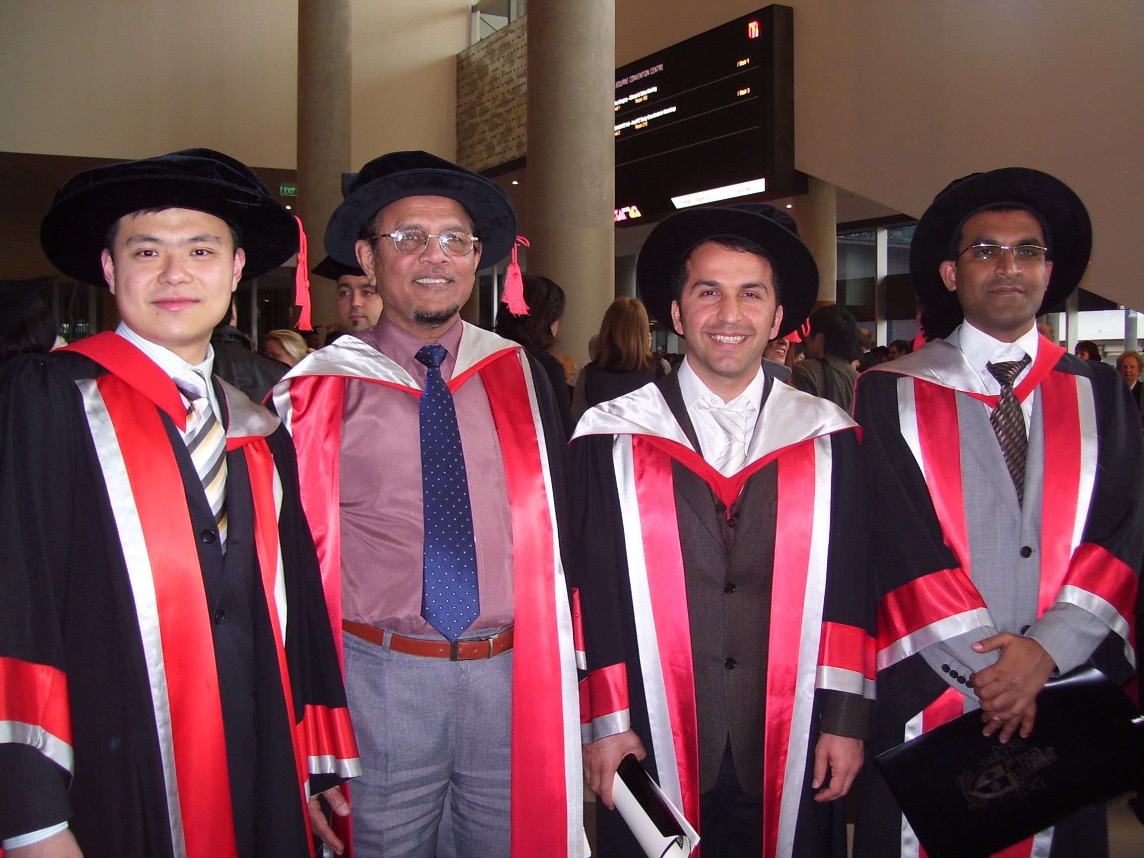 Professor Masood stands second from the left with three of his 2021 PhD graduates. All are wearing robes with the Swinburne colours, red, white and black.
