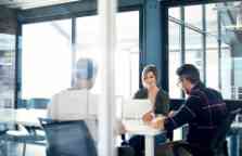 Photograph of a group of businesspeople having a discussion in an office.