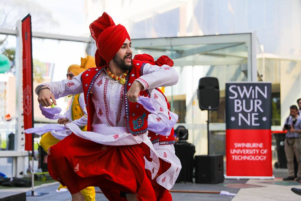 South Asian man in traditional attire dancing.