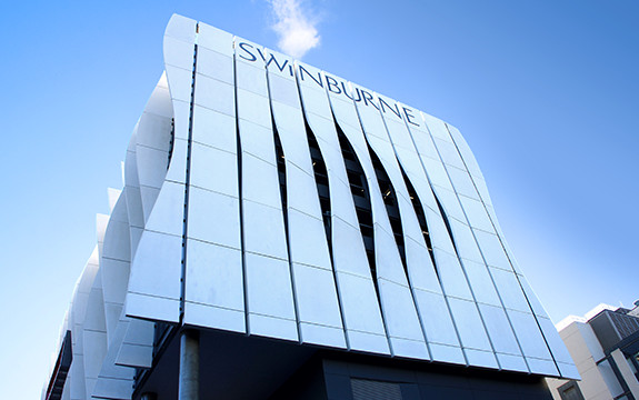 The large waved Swinburne signage of the Advanced Manufacturing and Design Centre building in Hawthorn which faces East down Burwood Road.