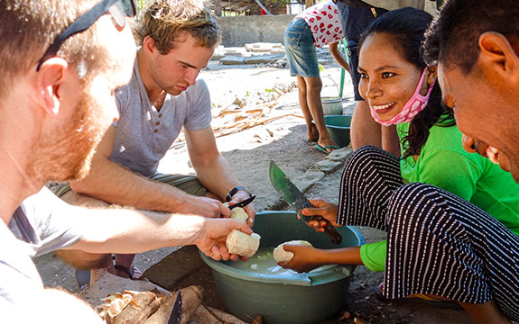 Students cutting fruit with Timor-Leste locals. 