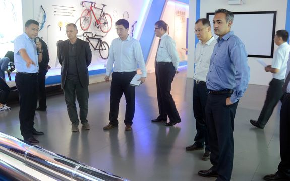Aleks Subic and colleagues stand in a line looking at bicycles