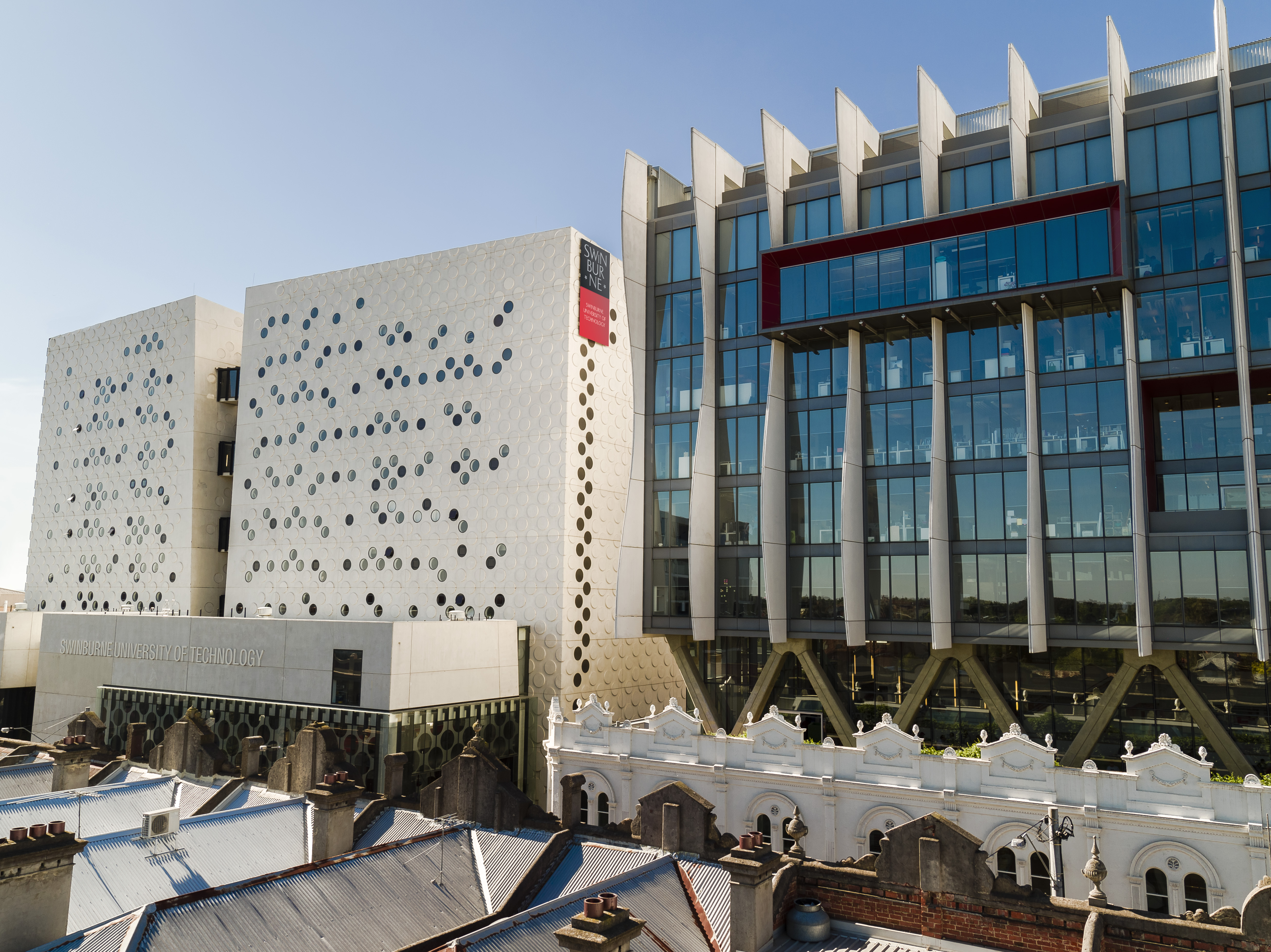 facades of modern looking buildings with glass front and round holes