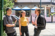 Group of 3 students chatting together on Glenferrie road
