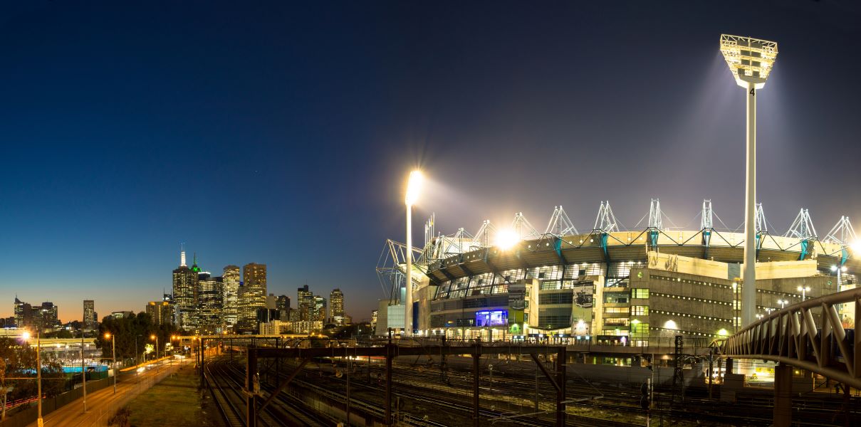 Night time image of Melbourne Cricket Ground with Melbourne city skyline in the background
