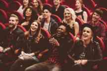Multi ethnic group of people in the theatre laughing