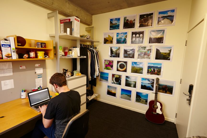 Person sitting at a desk in a bedroom