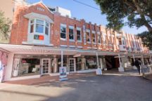 A street-view of the Junction building, it has a light brick base with white detailing on bannisters, windows and doors