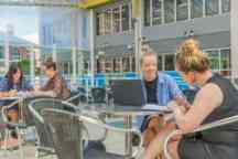 Four female students sitting in an atrium studying