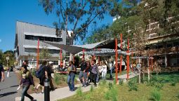 students walking along the pathway next to the GS and SR buildings on a bright sunny day