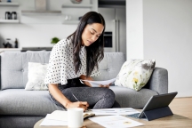 Woman analyzing documents while sitting at home