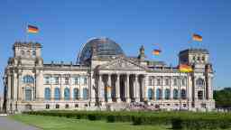 Reichstag in Berlin with German flags and blue sky