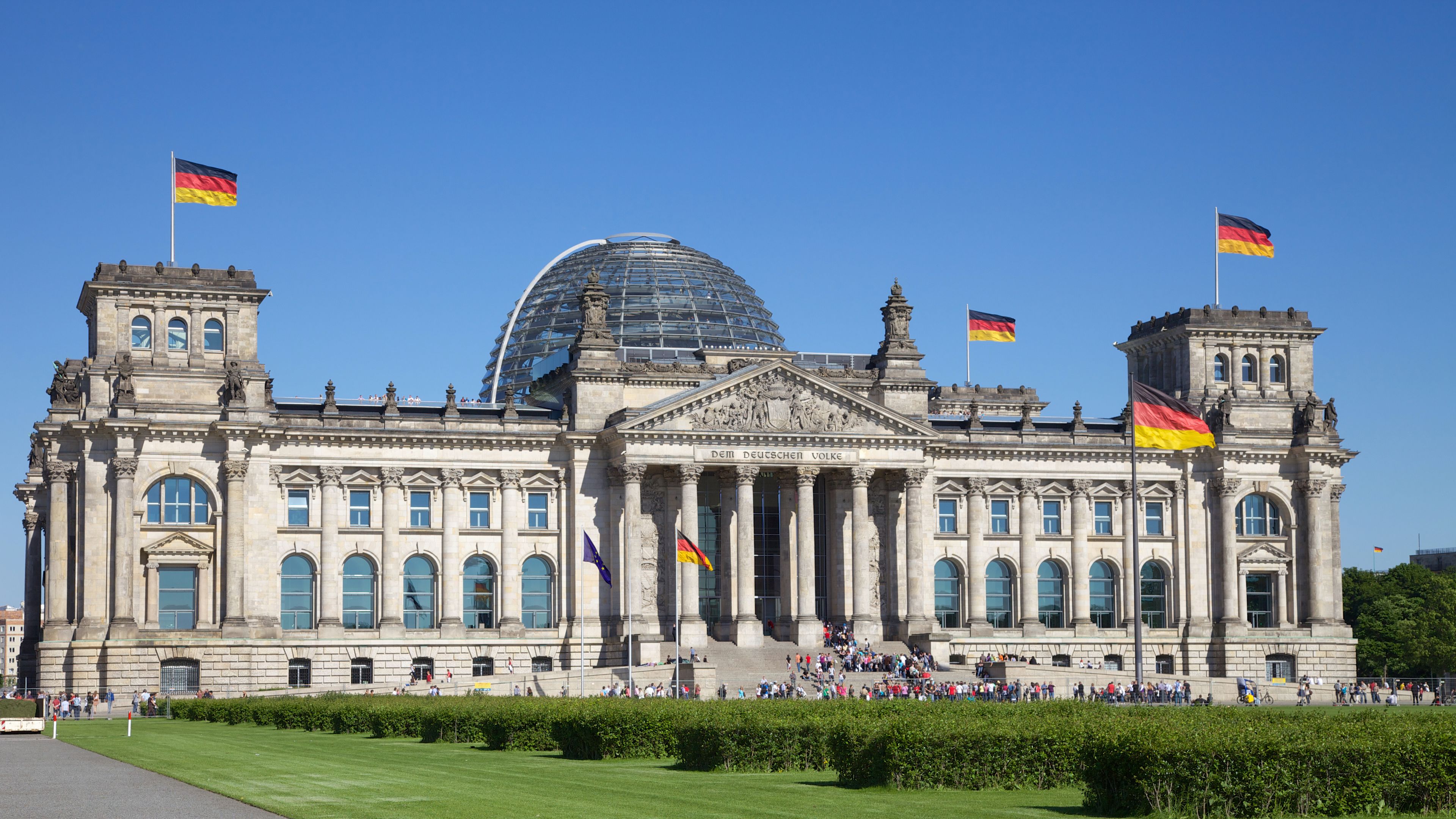Reichstag in Berlin with German flags and blue sky