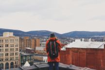 Student looking out at the view of a city with a backpack on