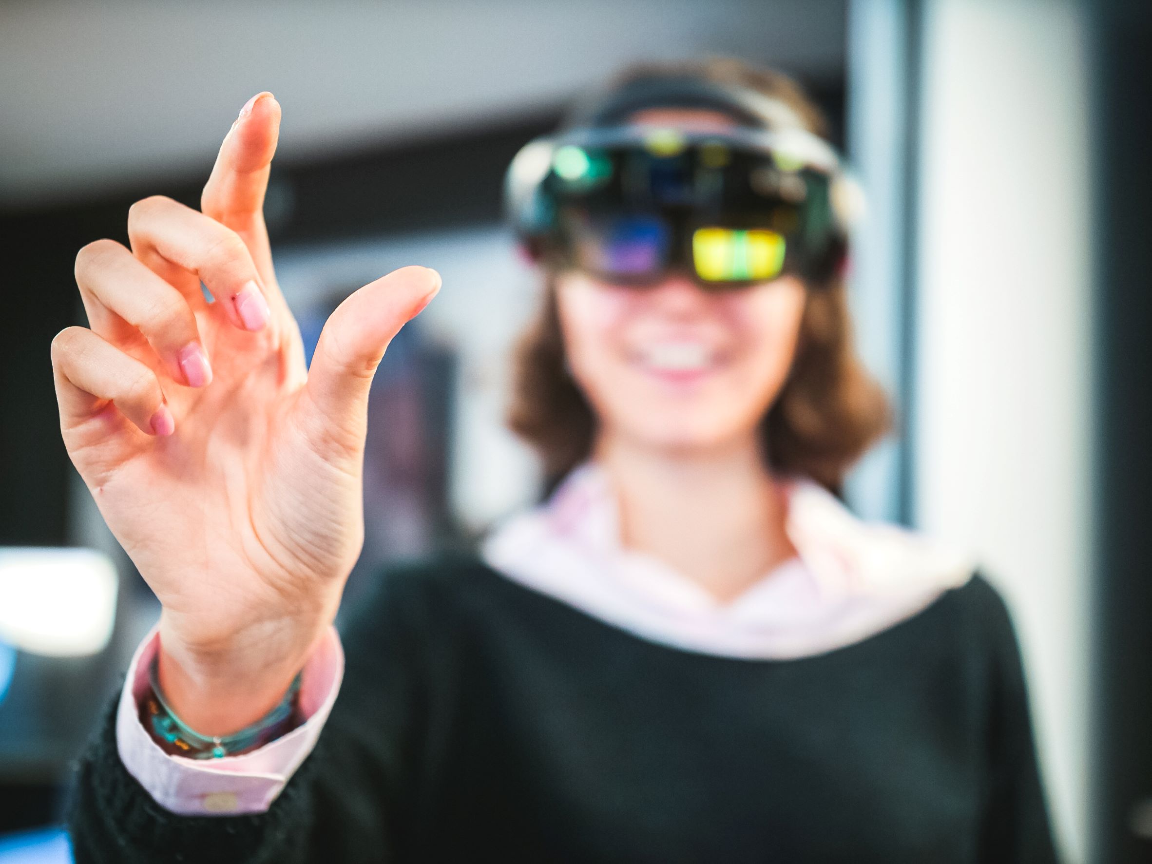 A woman wearing a VR headset reaching their hand out