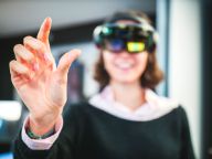 A woman wearing a VR headset reaching their hand out