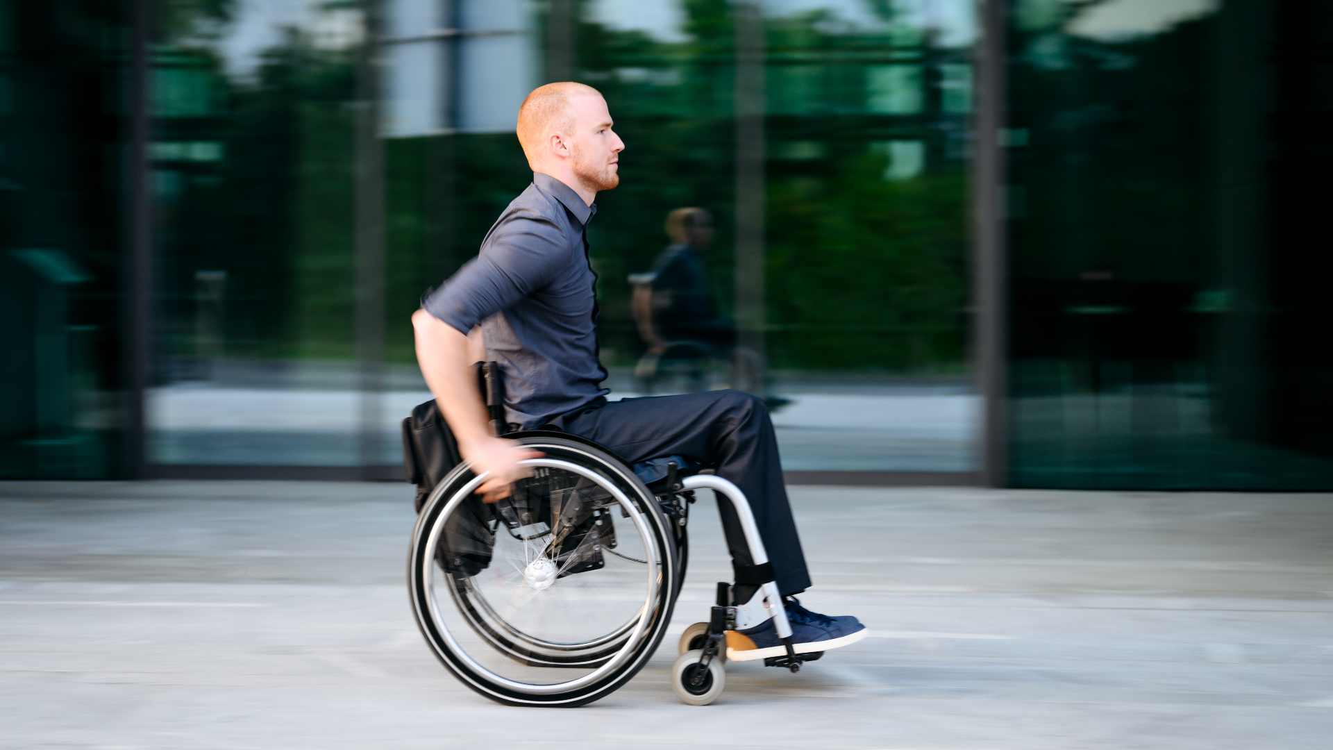 A man wearing a navy blue shirt on a wheelchair