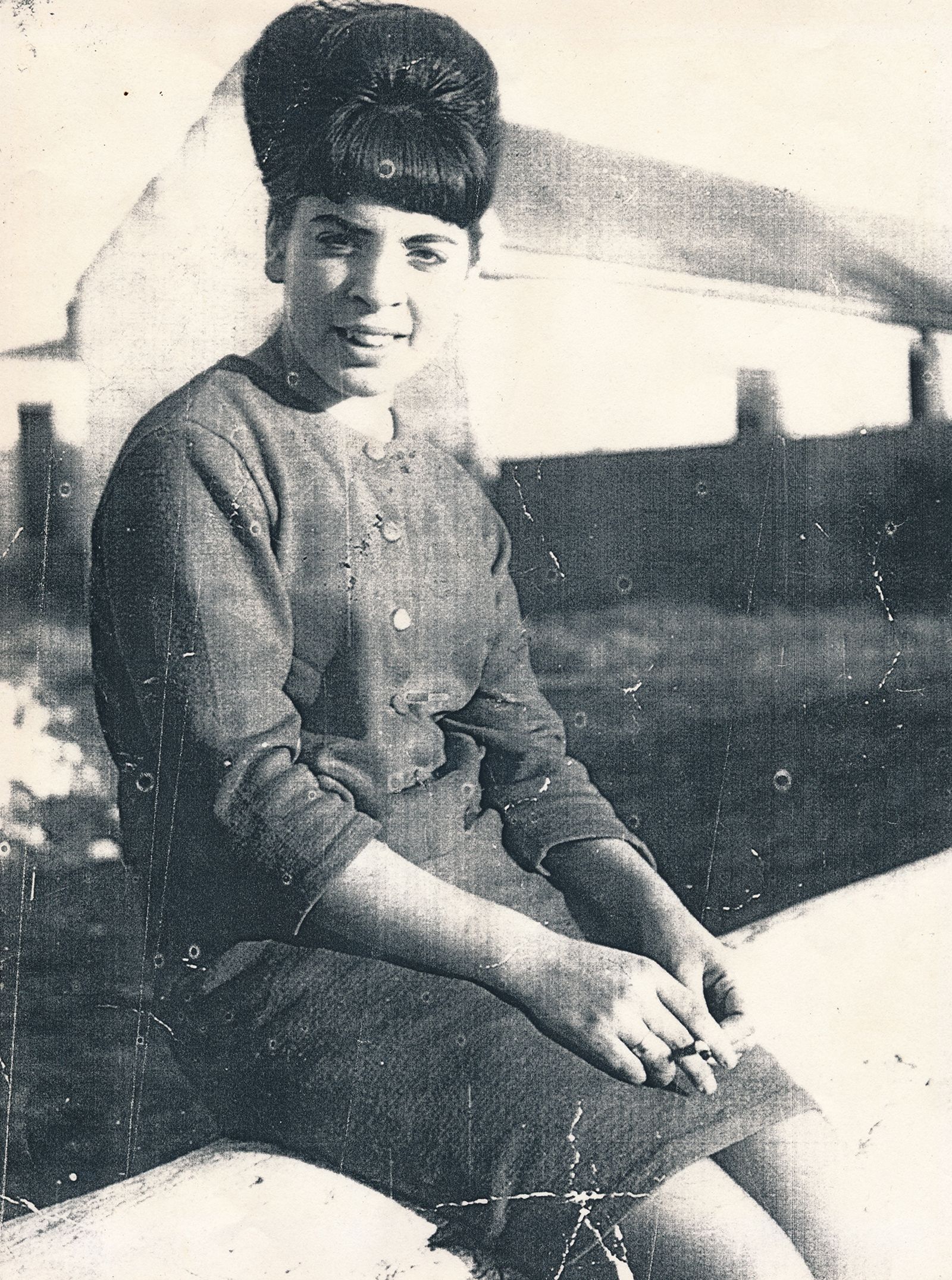 Woman seated in fron of old cottages