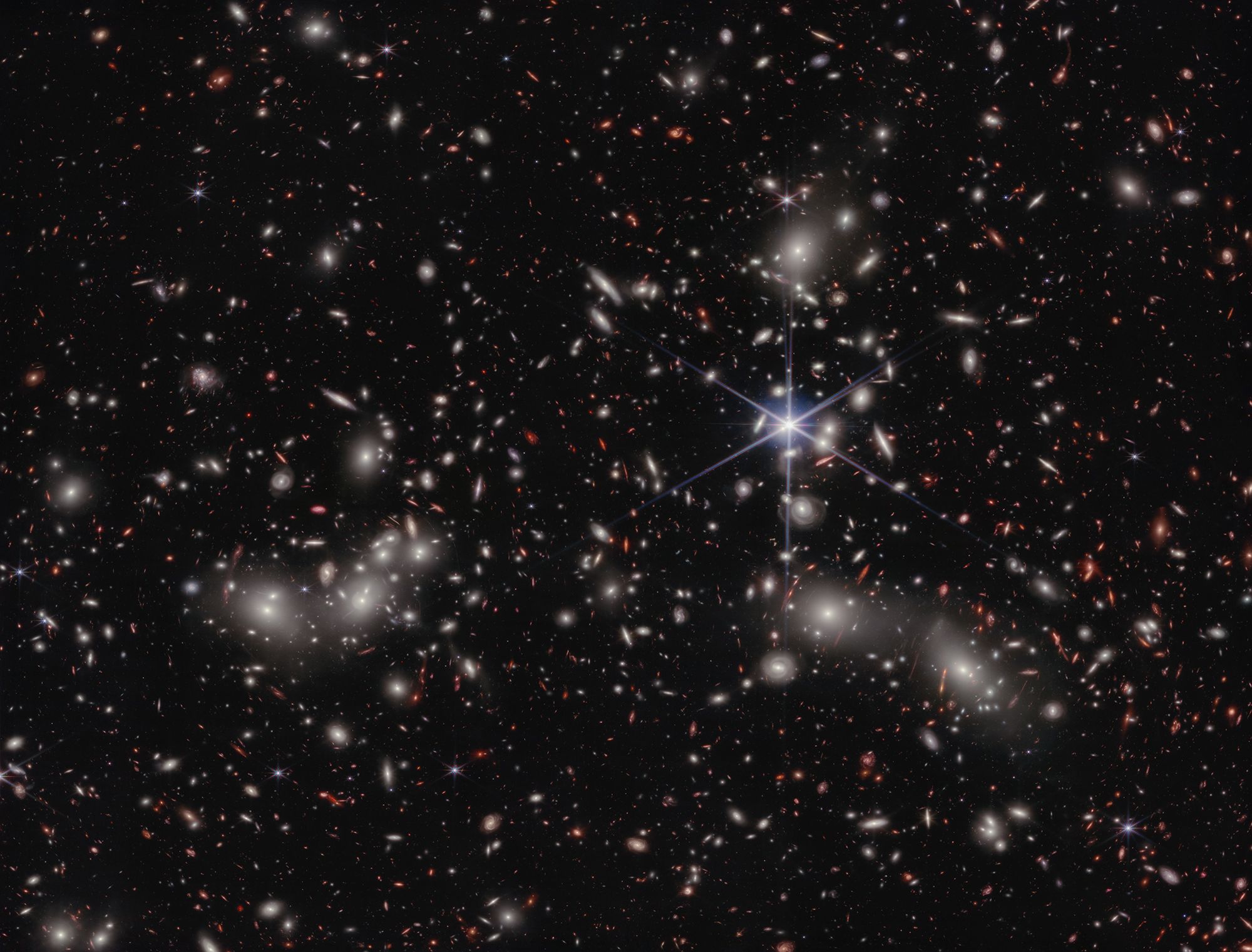 A foreground star to the right of the image centre, displays JWST’s distinctive diffraction spikes. Bright white sources surrounded by a hazy glow are the galaxies of Pandora’s Cluster, a conglomeration of already-massive clusters of galaxies