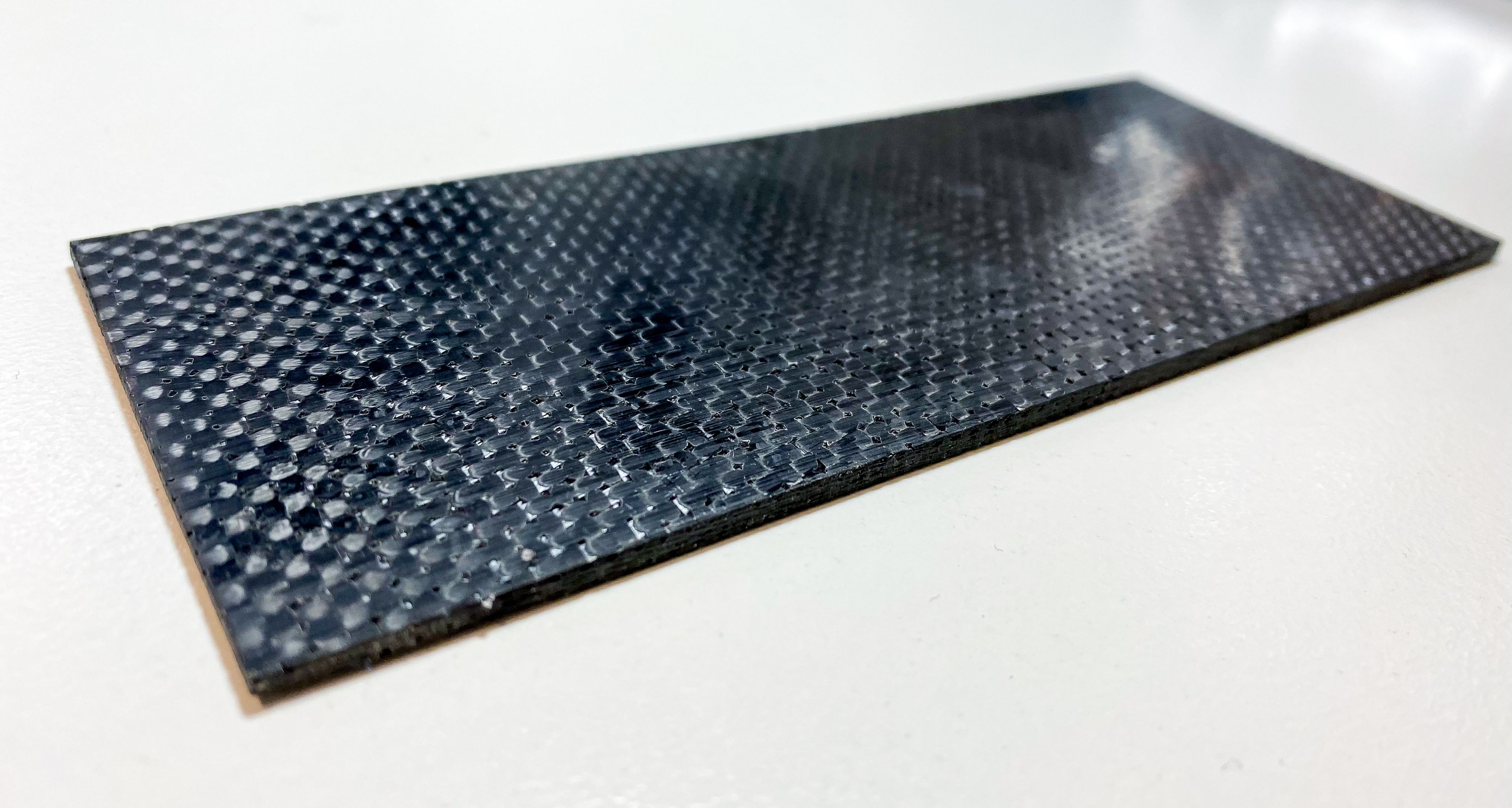 A black reflective graphene material on a white desk