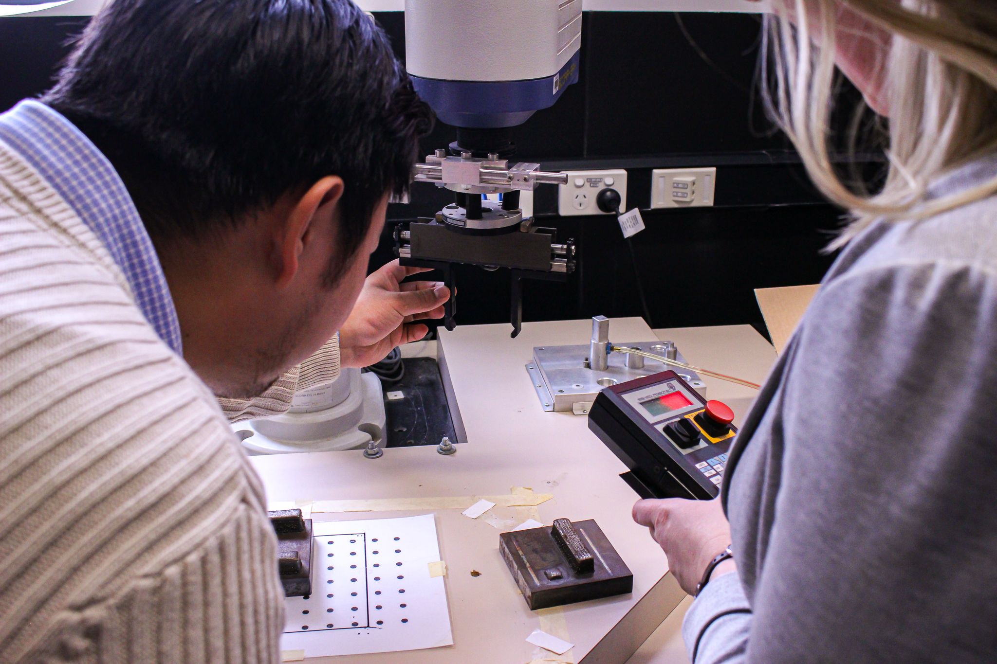 Two people in the AIR Hub working with equipment on a table